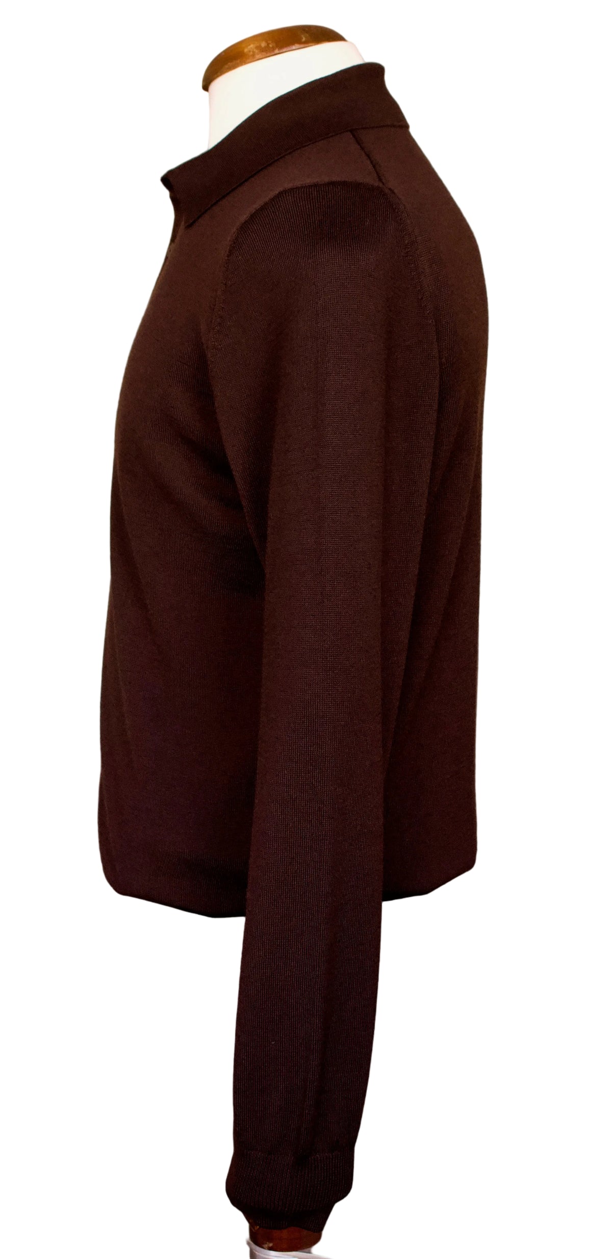 A dark brown long-sleeve knit sweater displayed on a mannequin torso in an indoor showroom setting.