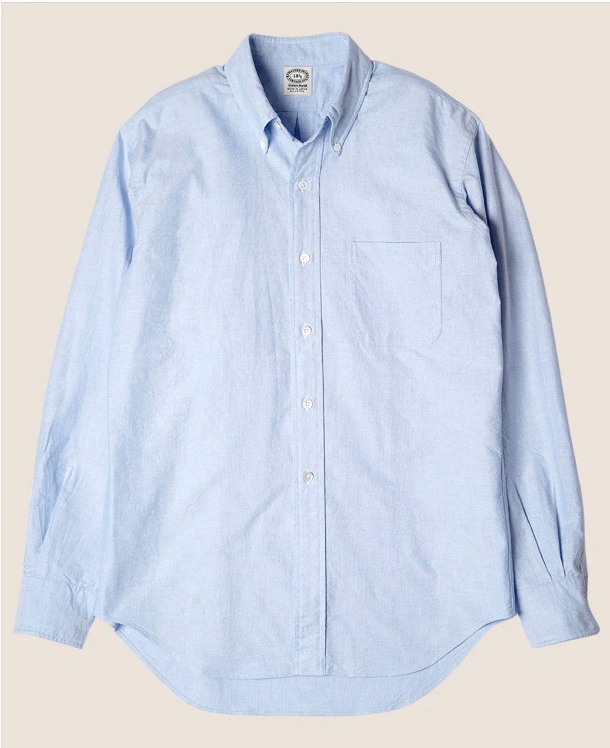 Light blue button-up shirt on a beige background