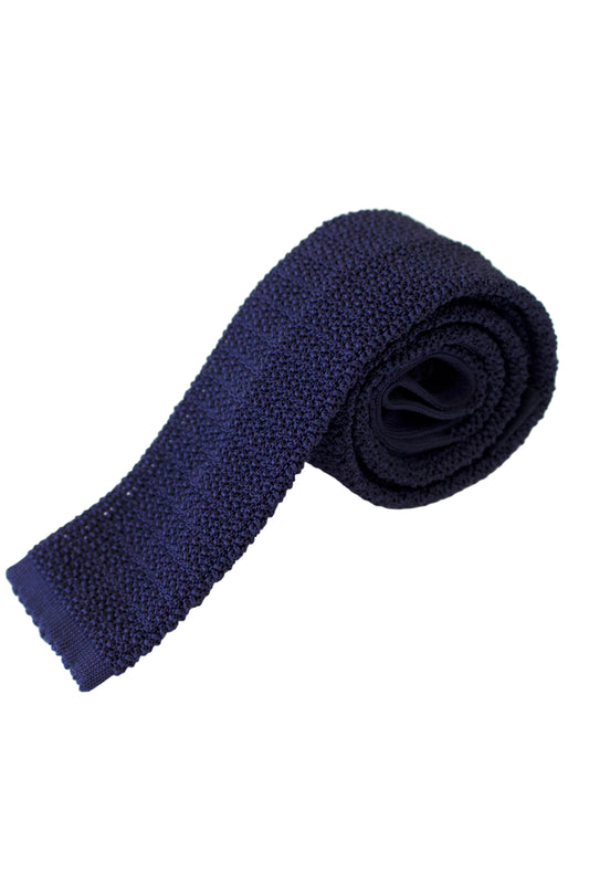 A rolled-up navy blue textured knit tie on a clean white background.