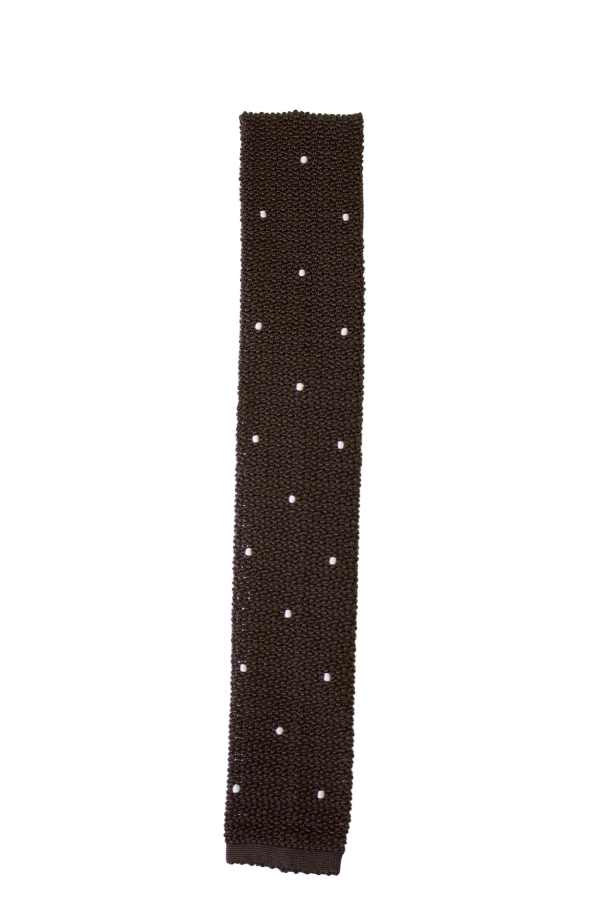A dark brown knit sleeve or wristband with small white polka dots, laid flat on a white background.